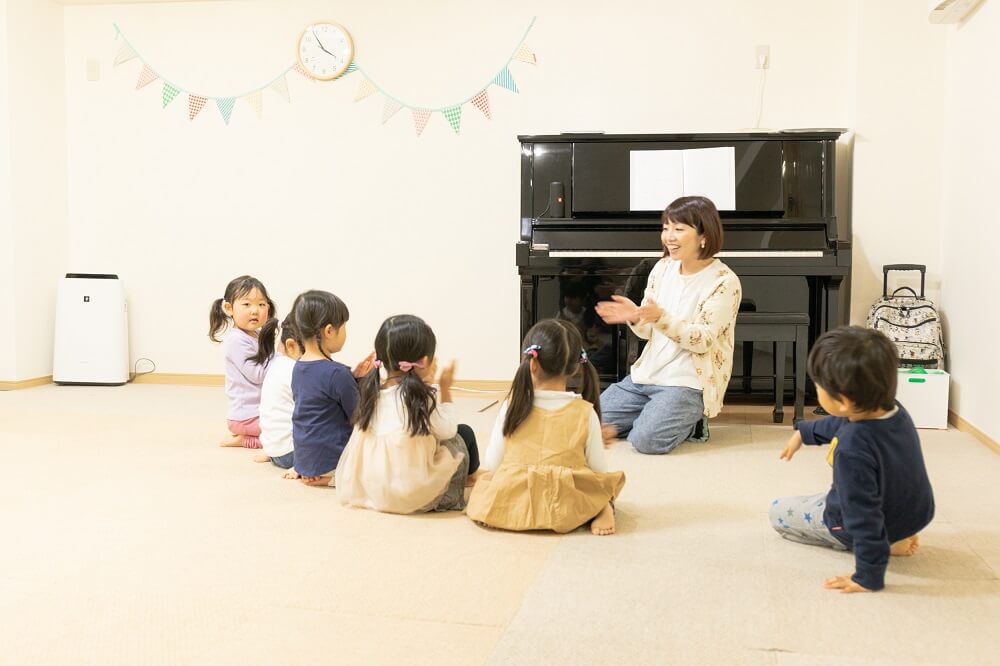 ニコットミュージック瑞江教室のリトミックレッスン。5人の子供たちが講師の話を聞いている写真。