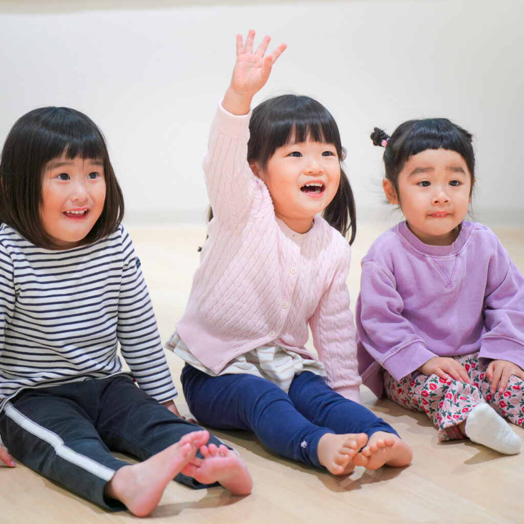 手を上げる3歳の子供たち