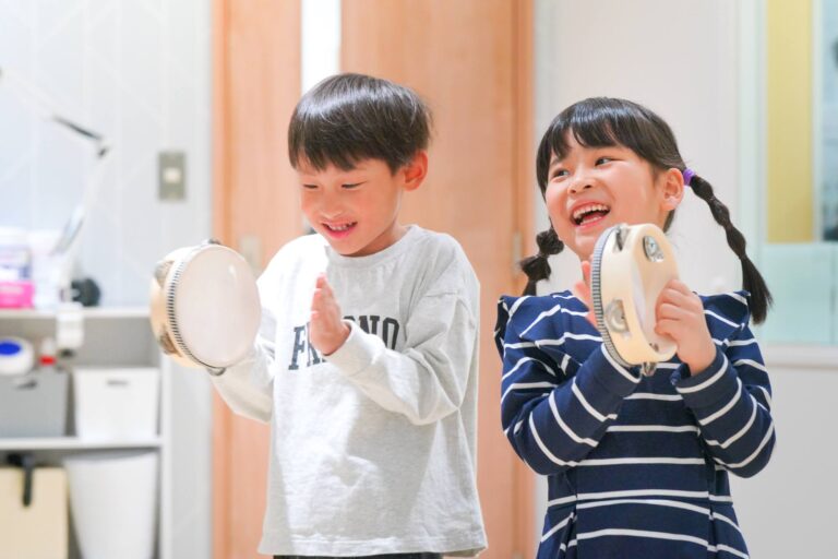 タンバリンでリズムを叩く男の子と女の子