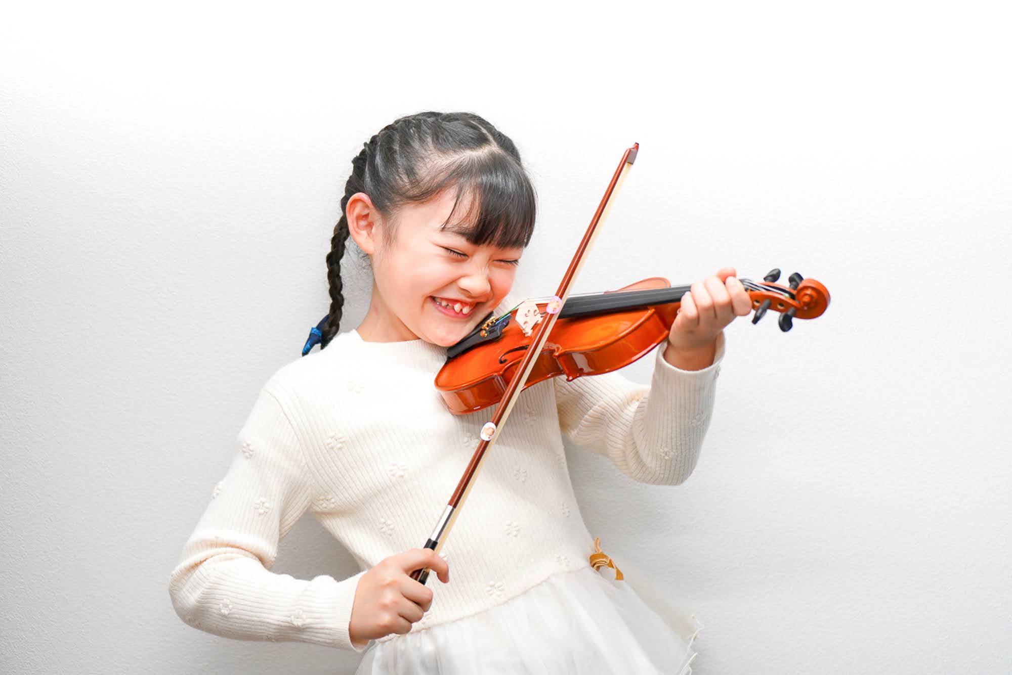 笑顔でバイオリンを弾く女の子