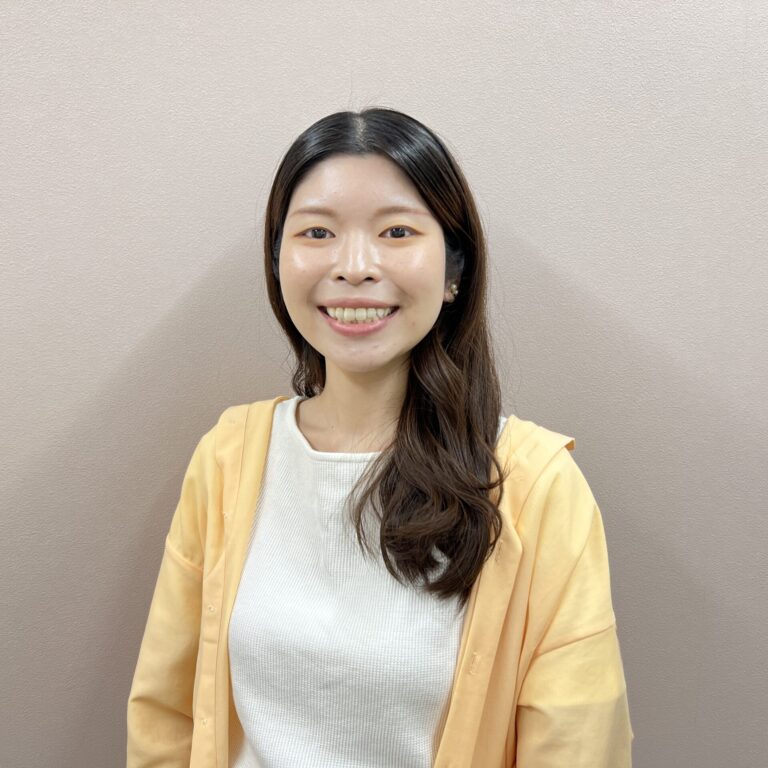 黄色いカーディガンを着た髪の長い女性