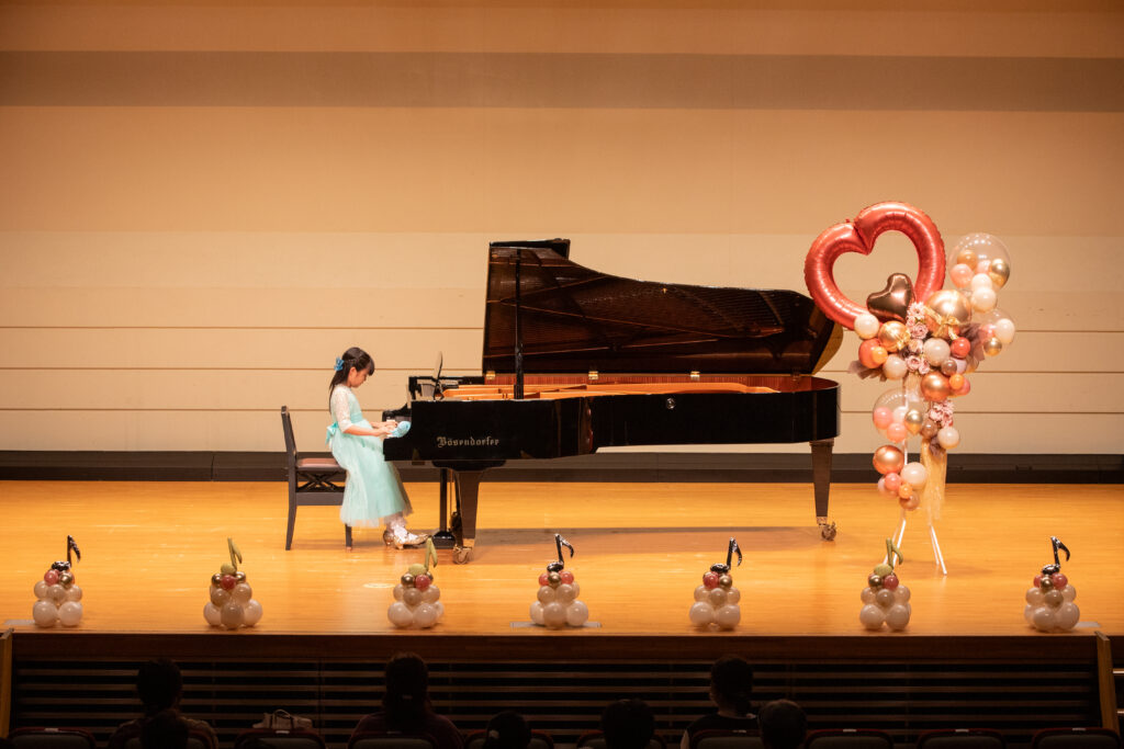 ピアノ発表会で演奏する子ども